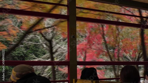 KYOTO, JAPAN - DECEMBER 2021 : View of riding on Sagano Romantic train (Sagano Scenic Railway) in Autumn leaves season. Saga torokko station to Kameoka torokko Station. photo