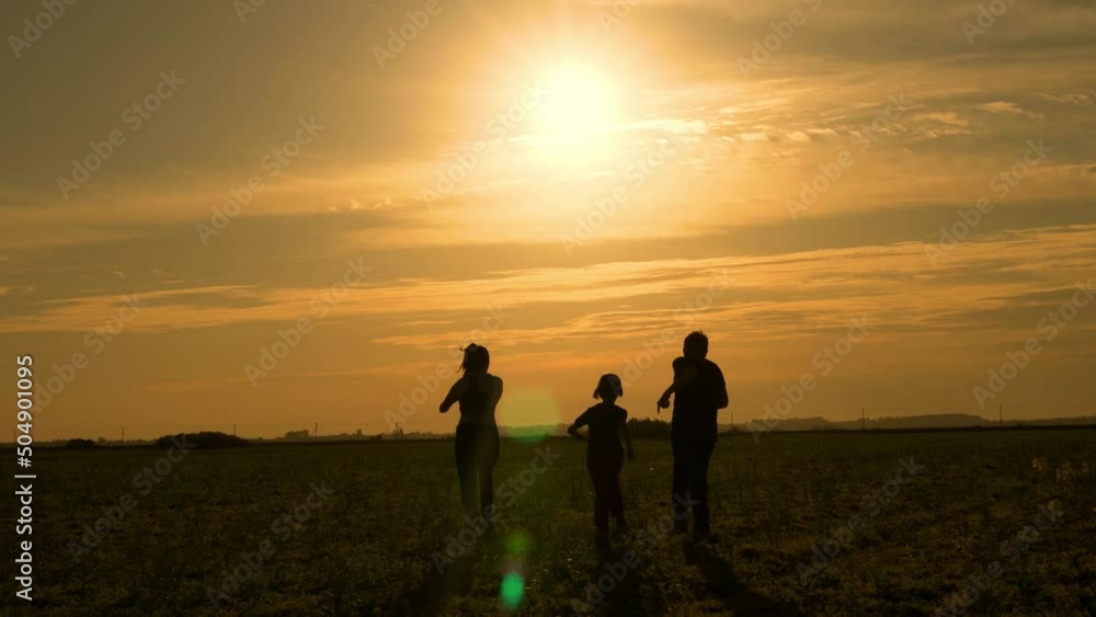 Happy Children Run across Field at Sunset. Children Play in Field, Run at Sunset, Silhouettes of Children. Concept of Happy Childhood, Friendly Happy Family. Happy Children Run across Field at Sunset. Children Play in Field, Run at Sunset, Silhouettes of Children. Concept of Happy Childhood, Friendly Happy Family.