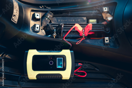 Fotografi Charging electric power, energy to accumulator or dead battery in breakdown motorcycle for start