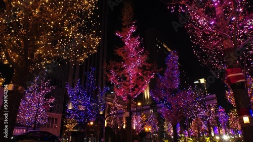 OSAKA, JAPAN - DECEMBER 2021 : View of Christmas illumination led light up at Midosuji street. Scenery of downtown city and street at night. Japanese winter and Christmas season concept. photo