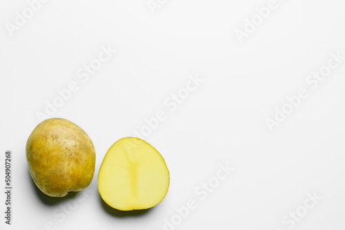 Top view of cut and whole potatoes on white background.