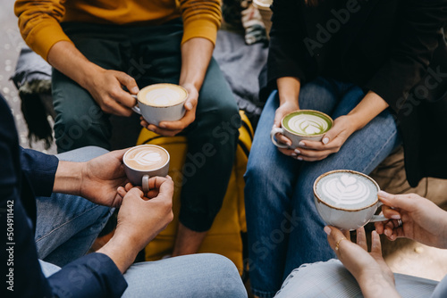 Group of people holding different coffee mugs with blue  yellow and green matcha latte.