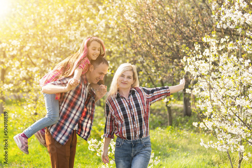 Happy family spending good time together in spring in a flowering garden