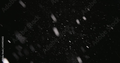 White snow falling against dark background