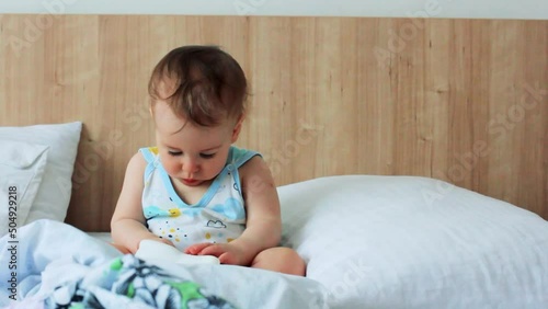 Cute little boy playing with toy lamp in bed