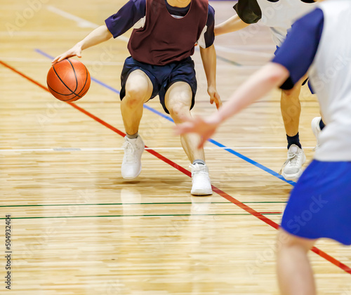 体育館でバスケットボールをする学生 © taka