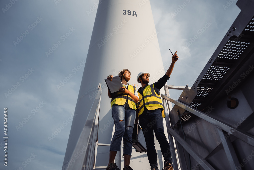 © Pituk - Young man and woman maintenance engineer team working and holding the report in wind turbine farm. Generator station, renewable energy © Pituk - Young man and woman maintenance engineer team working and holding the report in wind turbine farm. Generator station, renewable energy