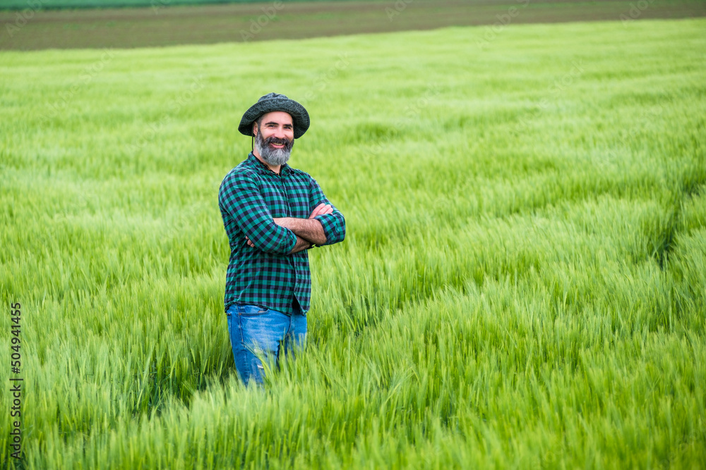 Happy farmer is standing in his growing wheat field. Happy farmer is standing in his growing wheat field.
