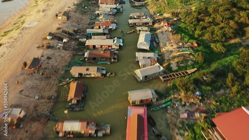 The traditional houses of Chong Kneas Floating Village towards Tonle Sap Lake in Asia, Cambodia, towards Siem Reap, in summer on a sunny day. photo