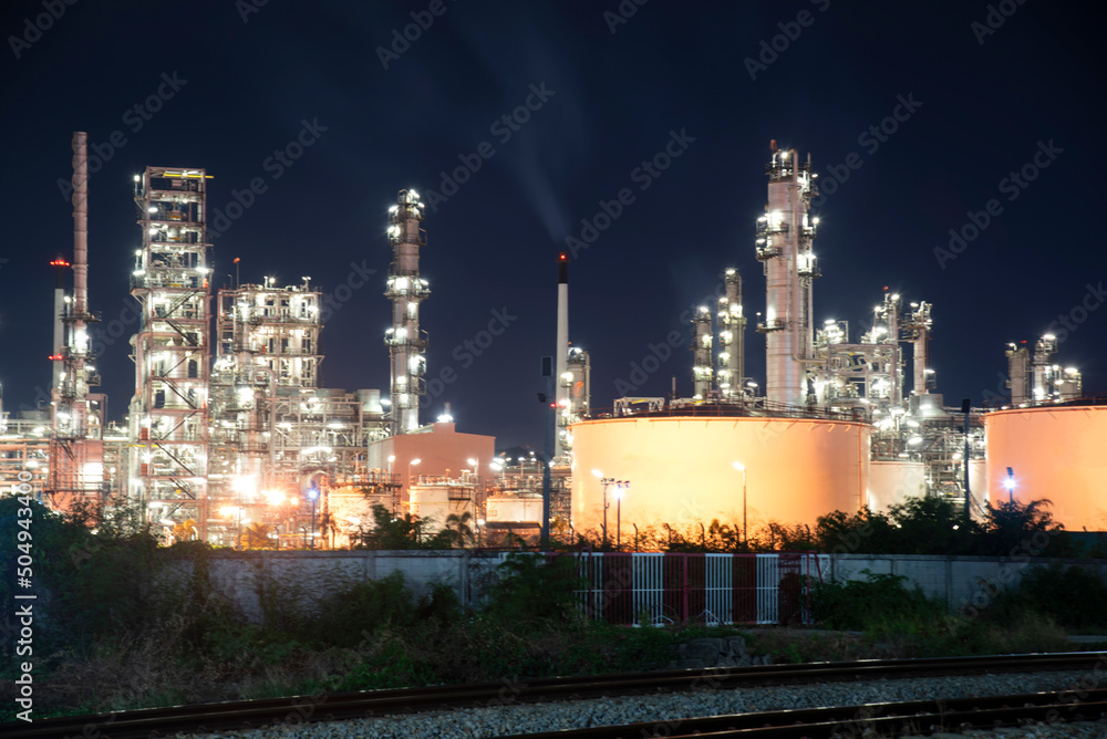 Oil refinery plant chemical factory and power plant with many storage tanks and pipelines at sunset