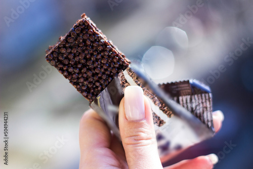 Woman holding a cereal bar ready to eat