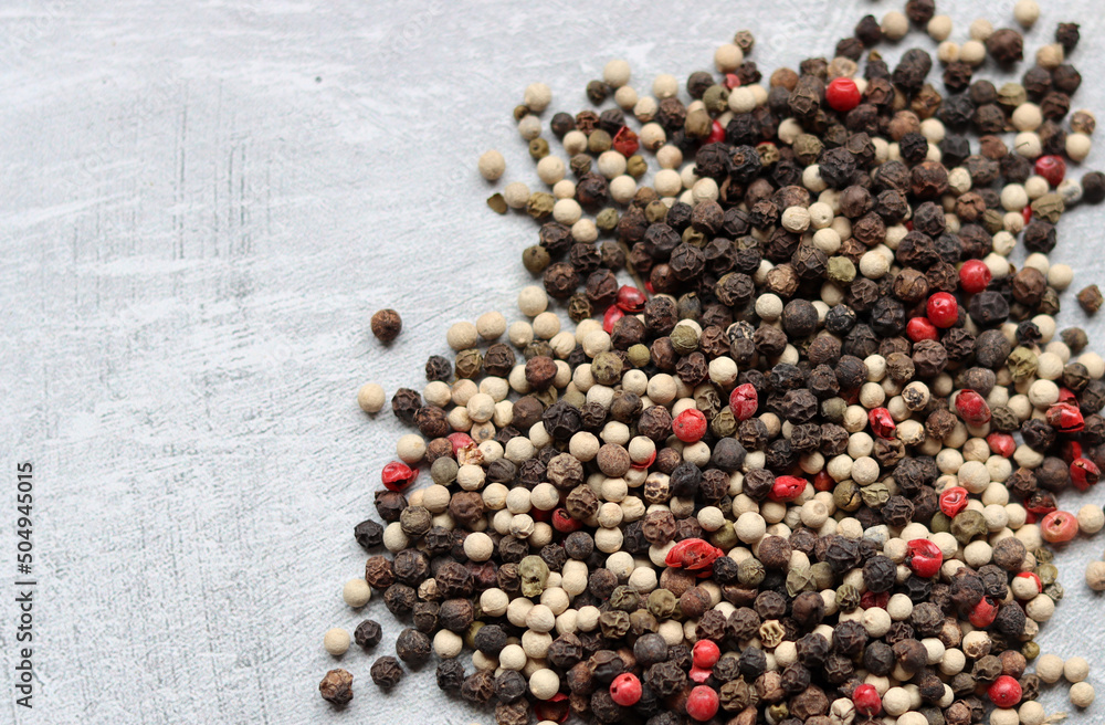 Peppercorns on a table. Light grey background with copy space. Colorful photo of spices. Peppercorns on a table. Light grey background with copy space. Colorful photo of spices.