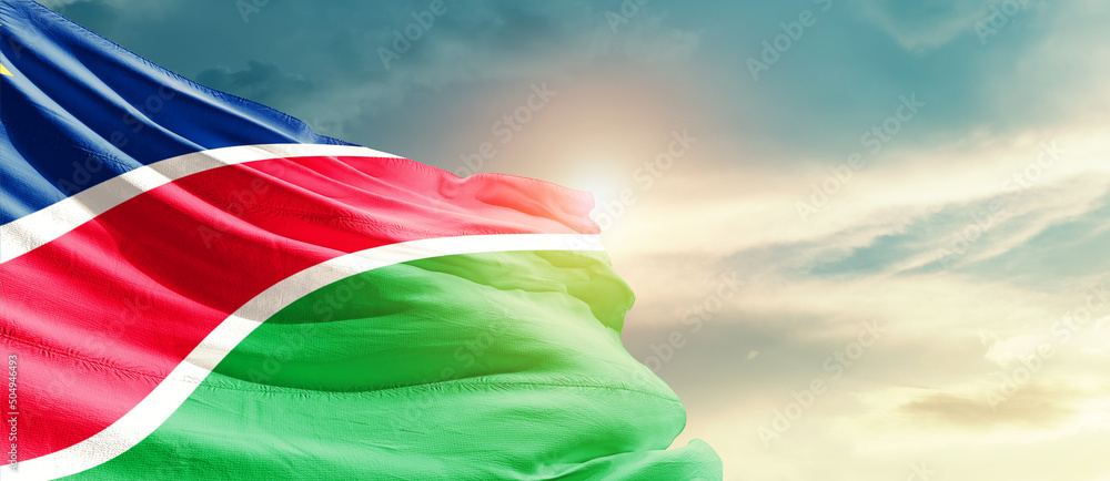 Namibia national flag cloth fabric waving on the sky - Image