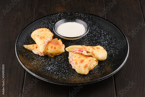 Thin pancakes stuffed with ham and cheese