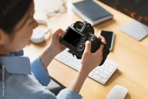 Portrait Of Asian Woman Holding Photo Camera Looking At Screen