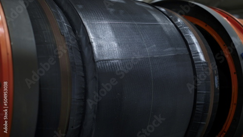 Employee on tyre manufacture maintaining production process touching tape