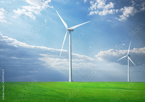 Wind turbine in green grass landscape with blue sky with clouds and sunshine