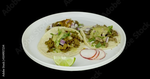 Three tacos of meat with sauces on a turntable. Mexican food. photo