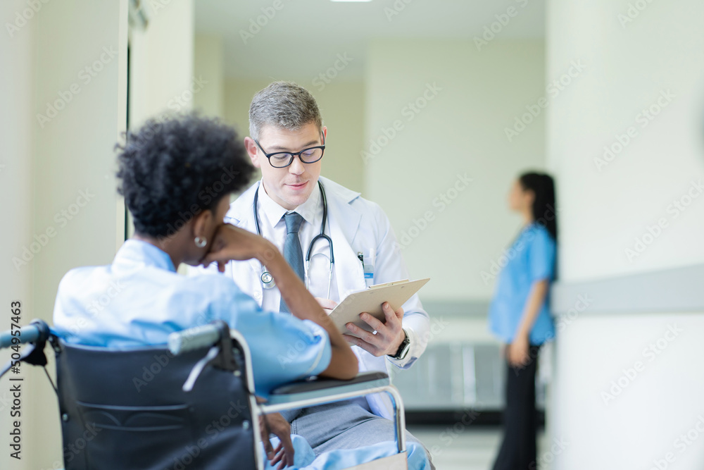 A male doctor in a medical uniform is discussing something with a patient in the hospital., Medicine and healthcare concept.