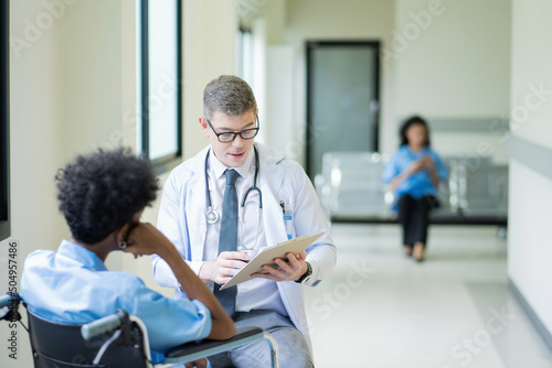 A male doctor in a medical uniform is discussing something with a patient in the hospital., Medicine and healthcare concept.