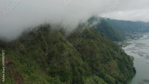 Clouds hanging above Trunyan hill at Lake Batur in Bali, natural volcanic landscape, aerial photo