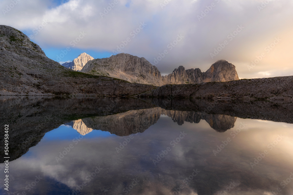 Sunset in the mountains of the Julian Alps. Evening reflections in the mountain lake.