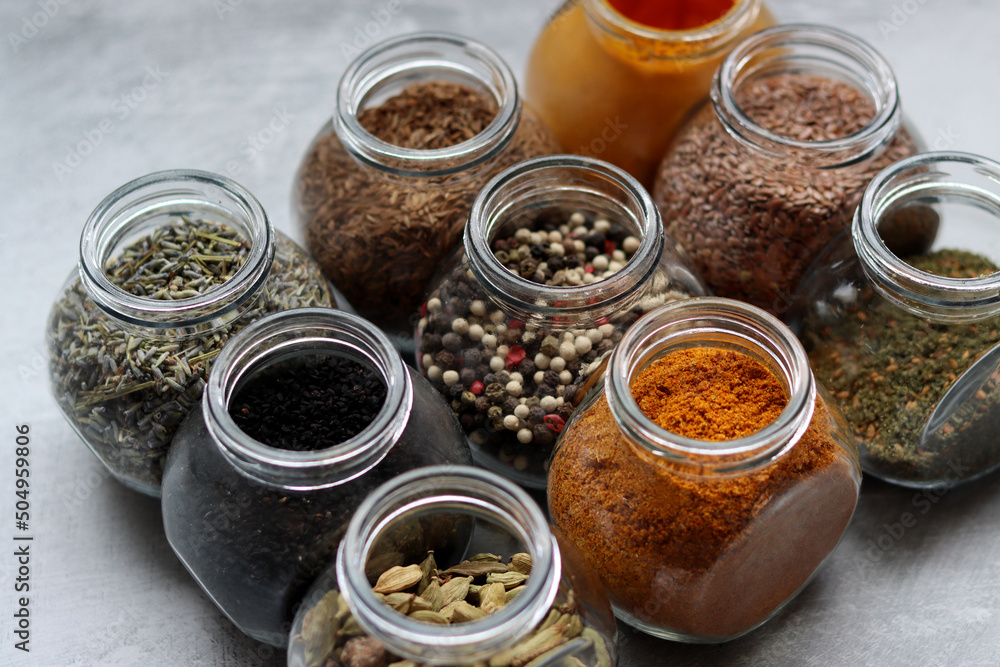 Close up photo of various spices in glass jars. Cardamom, flax seeds, mixed pepper, lavender, curry and turmeric. Close up photo of various spices in glass jars. Cardamom, flax seeds, mixed pepper, lavender, curry and turmeric.