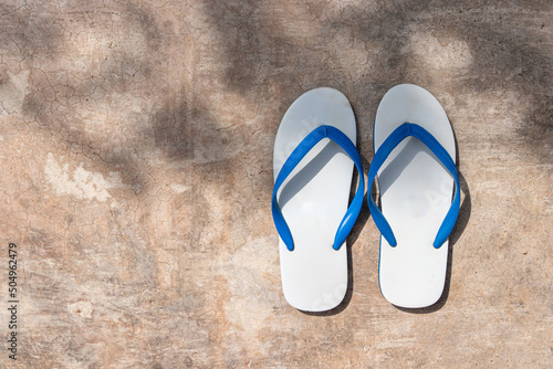 white and blue color slipper on concrete floor in a shade, casual shoes and footwear