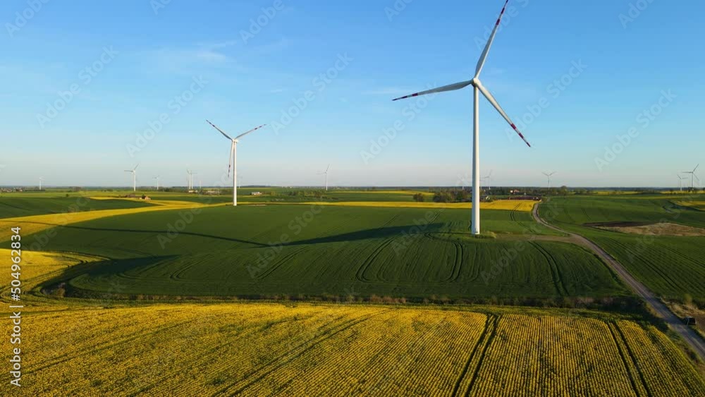 Big windmill in large agricultural field. Concept of electricity saving and alternative power source Big windmill in large agricultural field. Concept of electricity saving and alternative power source