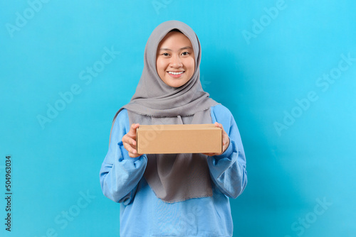 Fotografie, Obraz Young smiling Asian woman showing a packbox box