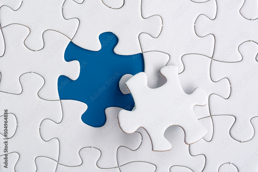 Piece of jigsaw puzzle on blue paper. Directly above. Copy space. Piece of jigsaw puzzle on blue paper. Directly above. Copy space.