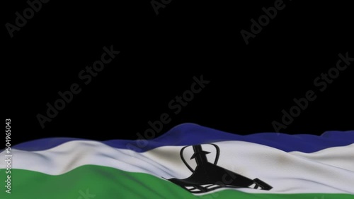 Lesotho fabric flag waving on the wind loop. Lesotho embroidery stiched cloth banner swaying on the breeze. Half-filled black background. Place for text. 20 seconds loop. 4k photo