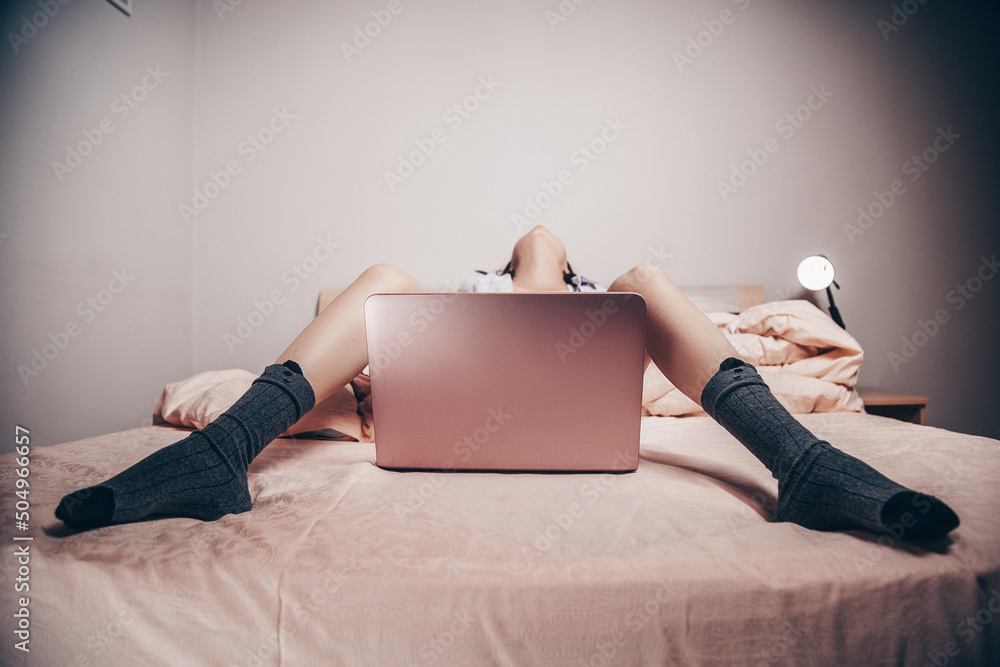 Foto Stock a young Asian webcam model girl is lying in front of a laptop  with her legs spread. enjoys and shows her charms. low depth of  focus,selective focus. | Adobe Stock