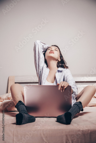a young Asian webcam model girl is sitting in front of a laptop. she  communicates and shows her charms. low depth of focus,selective focus  Photos | Adobe Stock