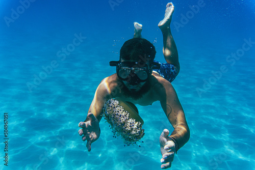Male model with a mask in a sea cave.