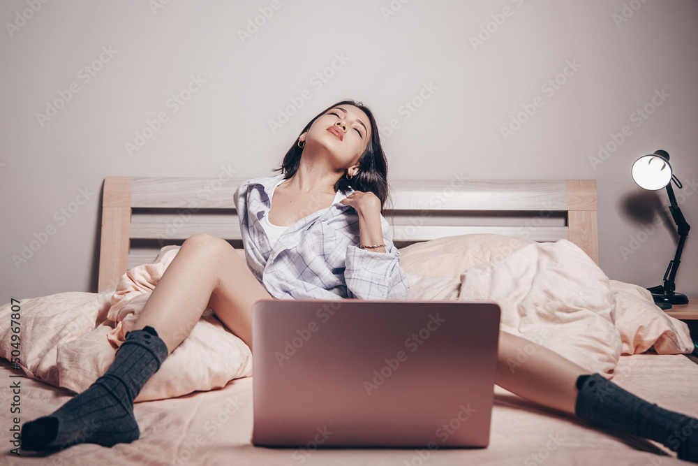 a young Asian webcam model girl is sitting in front of a laptop with her  legs spread. she communicates and shows her charms. low depth of  focus,artistic photo processing Photos | Adobe