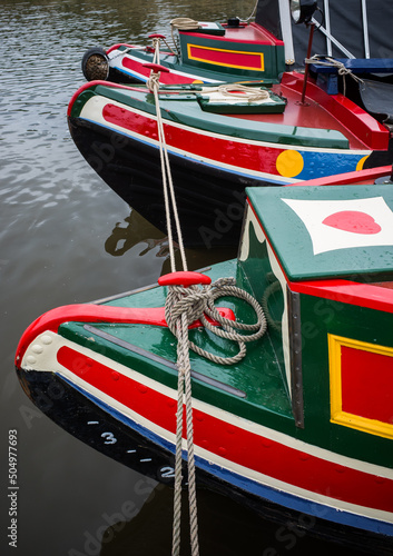 Traditional painted narrowboats moored in a row.