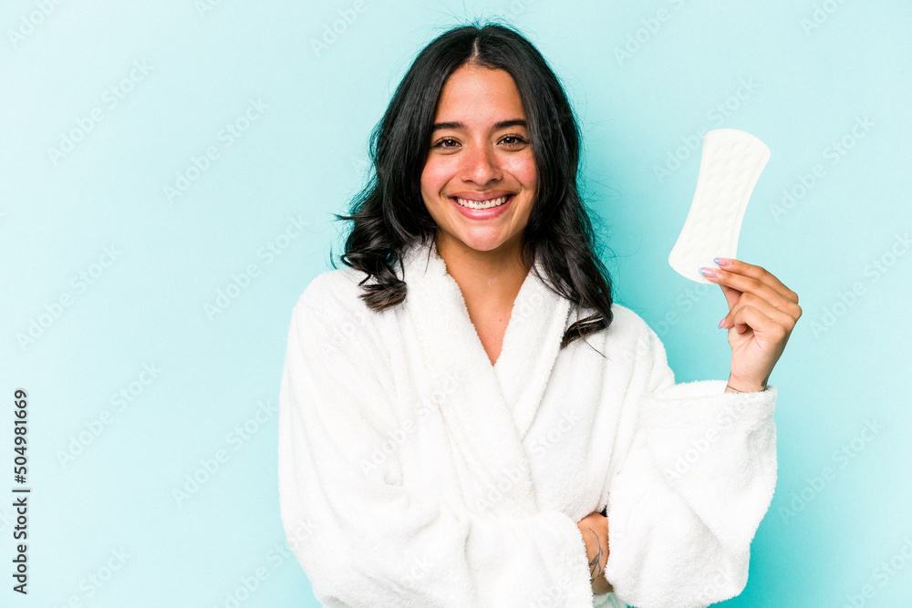 Young caucasian woman holding sanitary napkin isolated on pink background laughing and having fun. Young caucasian woman holding sanitary napkin isolated on pink background laughing and having fun.