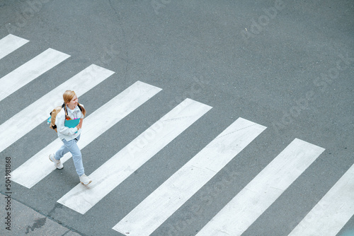 pupil crossing crosswalk and going to school outdoors in city photo