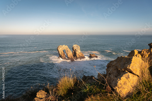 Beautiful seascape of the spectacular rock formations near the coast in the Cantabrian sea at sunrise, Urro del Manzano in Costa Quebrada, Liencres, Cantabria, Spain photo