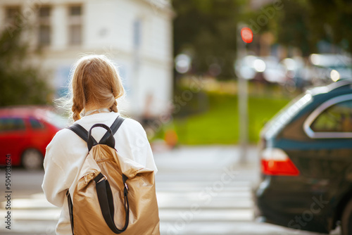 trendy school girl crossing crosswalk and going to school photo