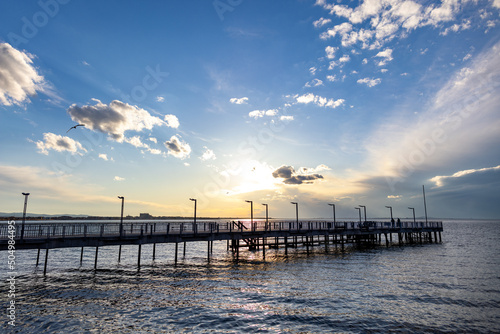 Side view of the pier on the Black Sea against the background of the sky and sunset