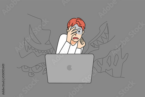 Scared boy watch horror movie on computer 