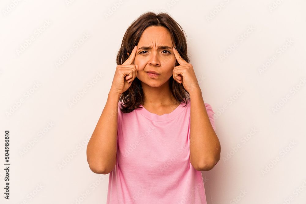 Young hispanic woman isolated on white background focused on a task, keeping forefingers pointing head. Young hispanic woman isolated on white background focused on a task, keeping forefingers pointing head.