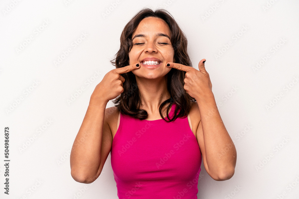 Young hispanic woman isolated on white background smiles, pointing fingers at mouth. Young hispanic woman isolated on white background smiles, pointing fingers at mouth.