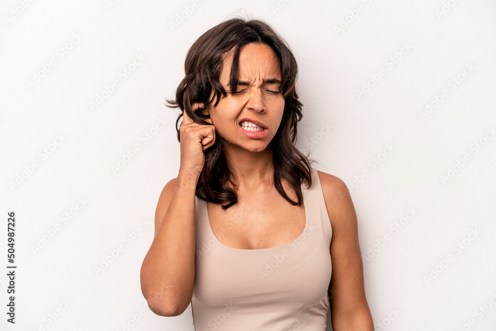 Young hispanic woman isolated on white background covering ears with hands. Young hispanic woman isolated on white background covering ears with hands.