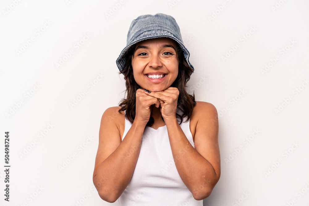 Young hispanic woman isolated on white background keeps hands under chin, is looking happily aside. Young hispanic woman isolated on white background keeps hands under chin, is looking happily aside.