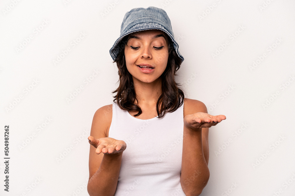 Young hispanic woman isolated on white background holding something with palms, offering to camera. Young hispanic woman isolated on white background holding something with palms, offering to camera.