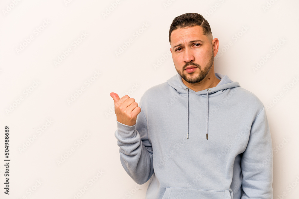 Young hispanic man isolated on white background shocked pointing with index fingers to a copy space. Young hispanic man isolated on white background shocked pointing with index fingers to a copy space.