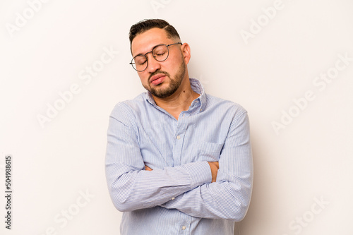 Young hispanic man isolated on white background tired of a repetitive task. © Asier
